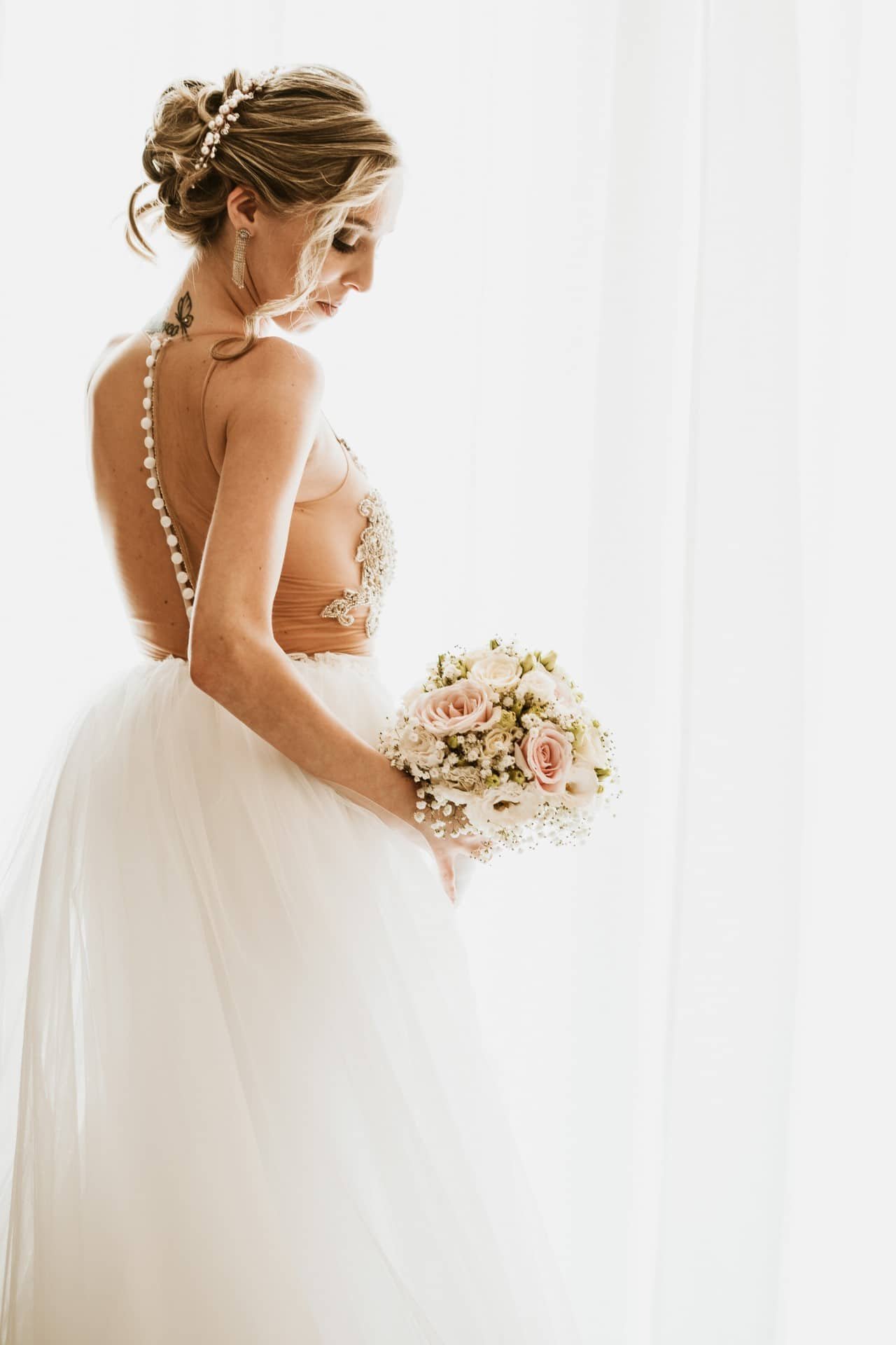 bride in her white dress holding her bouquet of flowers