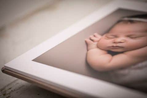 Open photography album with a blurred image of a baby on the page