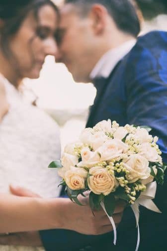 blured wedding photograph with bouquet of flowers in focus