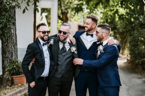 groom with friends smiling and wearing sunglasses