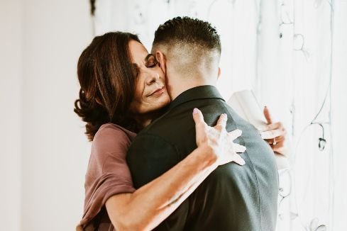 mother hugs her son as he goes off to get married