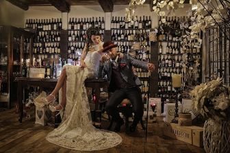 recently married couple posing in a wine celar