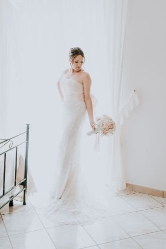 bride in her room posing in her white dress