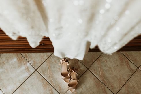 close up photo of a wedding dress and shoes