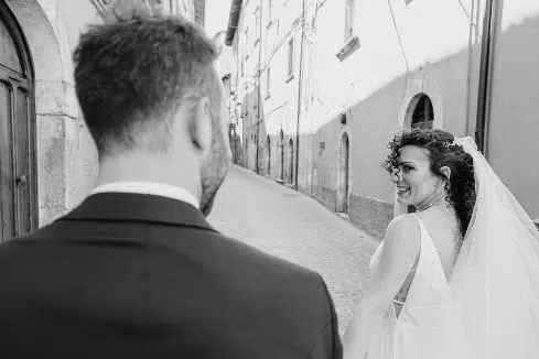 recently married couple walking along an Italian road in black and white